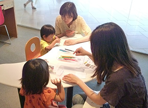 ミニミニアート体験で缶バッジづくりをする家族のようす