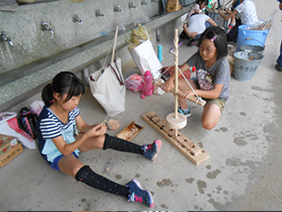 舞ぎり式火おこしに挑戦　この火で赤米を炊きます