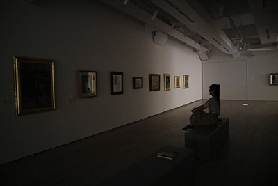 休館日の展示室で照明を暗くして作品を見たいという若者のアイデアから,真っ暗な中で絵画を鑑賞しました