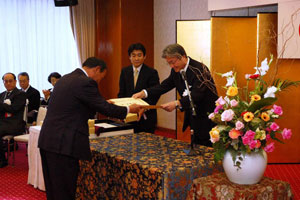 左野社長（左）へ青木長官から表彰状が手渡されました。