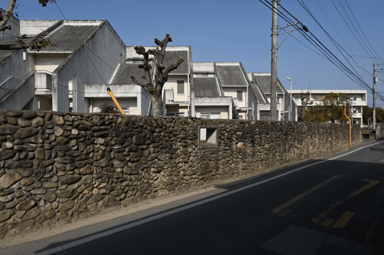 02_道路沿いの石積塀と建替え後の住宅