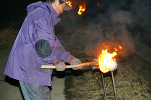 松明での点火（北秋田市三木田）