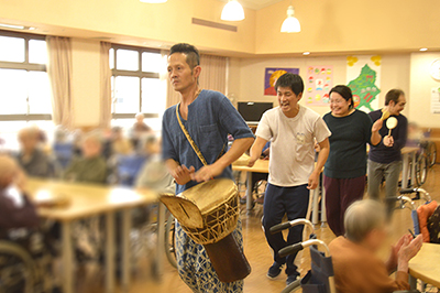 特別養護老人ホームで神楽太鼓奏者の石坂亥士とダンサーの山賀ざくろが身体を使ったワークショップをするようす