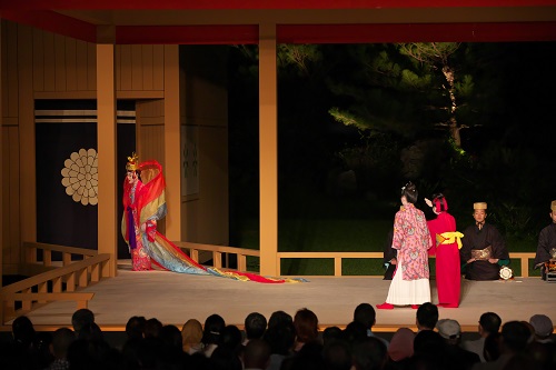 2019年の研究公演 組踊「銘苅子」。野外舞台で1719年の舞台を復元。天界(後方の橋掛り揚幕)へ向かう天女(新垣悟)と、見送る子供たち
