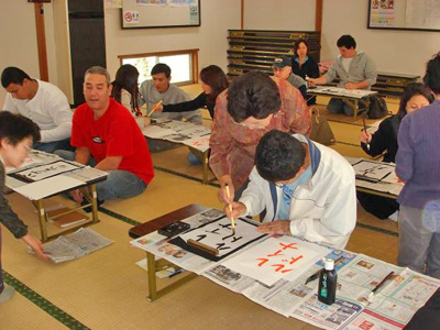 写真：書道体験 指導を受けながら名前を書いているところ